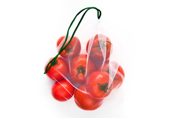 Red tomatoes in an environmental mesh bag on a white background
