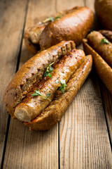 Tasty fresh hot dogs with grilled sausage on the rustic background. Selective focus. Shallow depth of field.