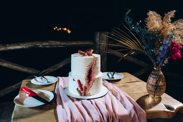 Layered wedding cake on the table.
Festive dessert.
