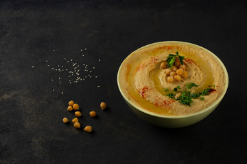 Humus. Chickpea puree appetizer. Dark background. Close-up.