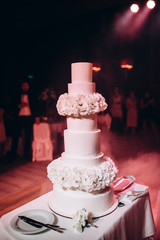 Layered wedding cake on the table.
Festive dessert.
