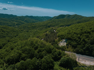 Mountain winding zig zag road. Top aerial view: cars driving on road from above.