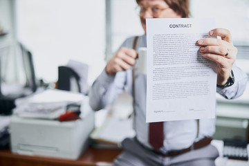 Paper document in hand of a middle-aged businessman