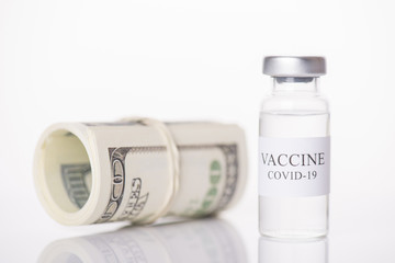 Expensive COVID-19 vaccine economy collapse impact currency concept. Close-up photo of vaccine vial and money stack isolated on white background