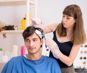 Obraz na płótnie Canvas Young attracrive man visiting female barber