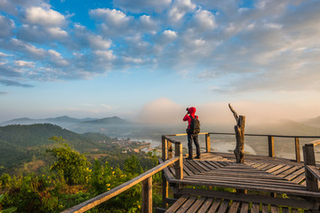 Fototapeta na wymiar Photographer on the wooden bridge on sunrise at Phu Lam Duan view point