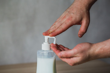 Hand soap dispenser bottle man using antibacterial soap to clean hands for coronavirus prevention COVID-19