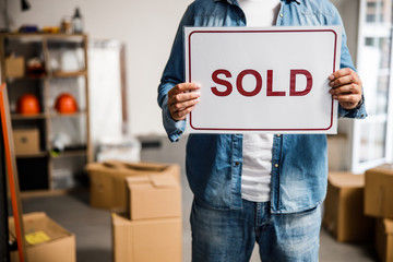 Man in denim wear holding sign sold in empty flat