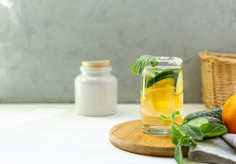 Refreshing cocktail with lemon and mint on a wooden stand, blurred background with space