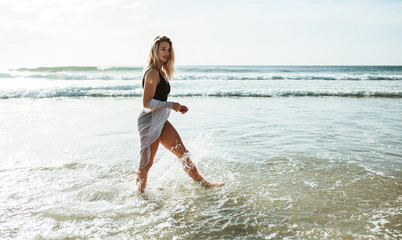 Fototapeta premium Woman walking in water at the beach