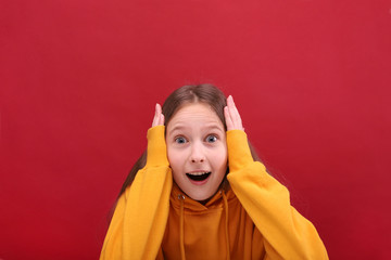 The frightened girl looks into the camera and holds on to her head.