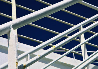 White metal stairs on the ferry. Blue sky background