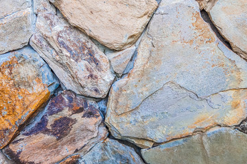 Beautiful background of closeup brown gray stone wall. Ideal for use in the design