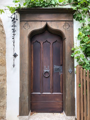 Wooden Castle Front Door with Cast Iron Handles, fench, and greenery - Europe