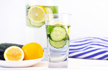 Health care, fitness, healthy eating concept. Fresh cool lemon cucumber drink with water, cocktail, detox drink, lemonade in a glass jug and a glass.