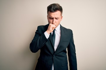 Young handsome business man wearing elegant suit and tie over isolated background feeling unwell and coughing as symptom for cold or bronchitis. Health care concept.