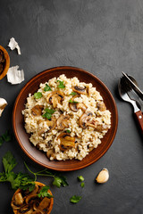 Traditional italian cuisine meal - vegetarian risotto with mushrooms. Black stone backround.