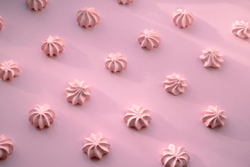 Tasty fresh and airy meringue dessert on a pink delicate background with tight shadows..