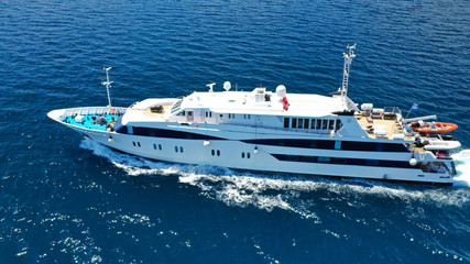 Fototapeta na wymiar Aerial drone photo of yacht cruising in high speed in open ocean Aegean deep blue sea, Greece