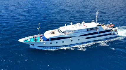 Fototapeta na wymiar Aerial drone photo of yacht cruising in high speed in open ocean Aegean deep blue sea, Greece