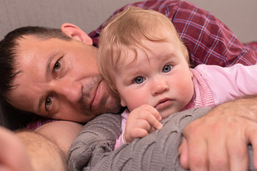 Father and little daughter look into the camera, close-up