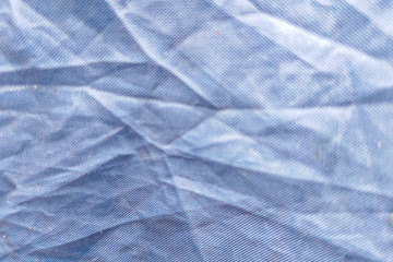 Beautiful closeup background with dark gray crumpled raincoat fabric. Ideal for use in the design or wallpaper