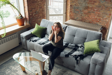 Obraz premium Going crazy. Young woman working or studying at home, looking on computer screen, monitor. Copyspace for your ad. Finance, business, work, gadgets and tech concept. Freelance, education, remote work.