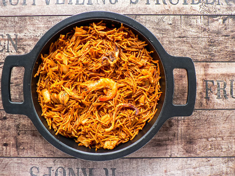 Noodle paella (fideuá). Typical Catalan dish made with noodles and seafood with garlic sauce and oil, wooden spoon
