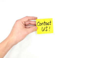Young male hand holding bright yellow contact us card isolated in white background.