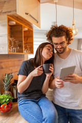 Couple using tablet computer and drinking coffee