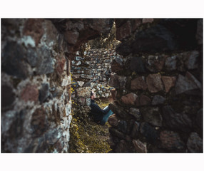 hombre sentado entre los escombros de un castillo