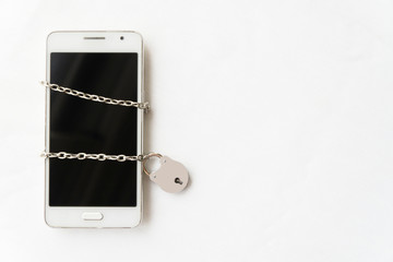 Censored mobile phone with chains and padlock. Technological detoxification concept.