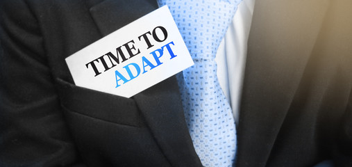 Time to adapt on a card in upper pocket of businessman. Crisis management business concept