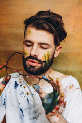 Portrait of a young creative artist, A man who enjoys drawing, his favorite hobby paint colors on a canvas