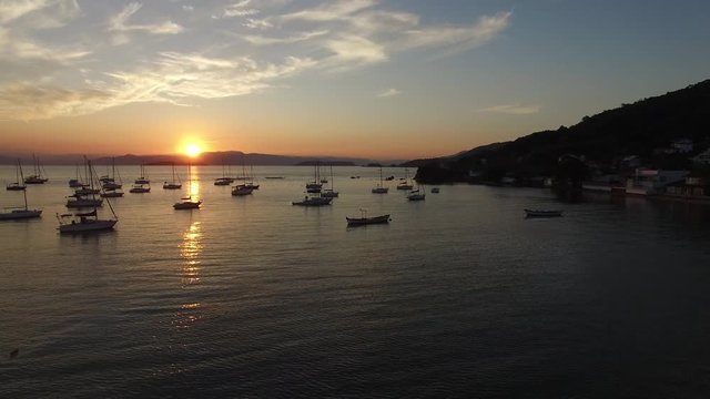 Por do sol em Santa Ant&ocirc;nio de Liboa, Florian&oacute;polis, com barcos ancorados na ba&iacute;a.