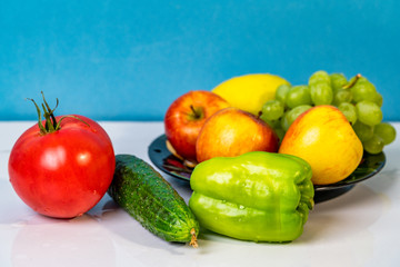 apples, lemon, grapes, pepper, tomato and green cucumber on white background
