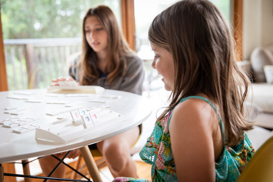 Sisters play a board game at home during shelter in place