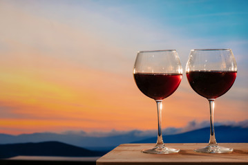 Glasses of red wine against sunset, red wine on the sky background with clouds - 352600329