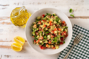 Top view of refreshing vegan summer couscous salad with vegetables on white