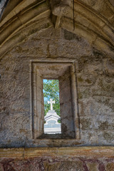 View of a stone cross through a window, in the cemetery of Cambados, Rias Bajas, Pontevedra, Galicia, Spain, Europe.