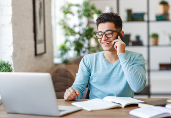 Cheerful ethnic freelancer answering phone call