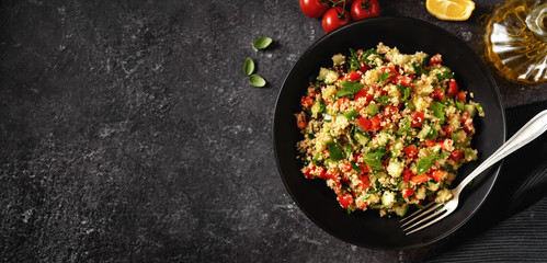 Fresh summer vegan couscous salad with vegetales and olive oil captured from above