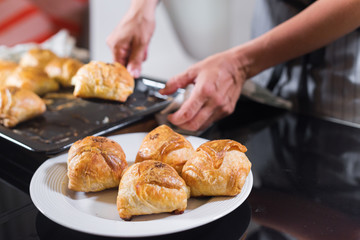 Female hands is taking a freshly baked samsa