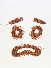 Flax seeds laid out in the form of emotions due to diet.