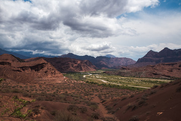 valles calchaquies norte argentino, montañas de colores con cielo interesante con nubes espesas y azul intenso