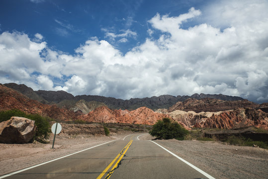 carretera o ruta por entre medio de las monta&ntilde;as en la naturaleza del norte argentino argentina jujuy con nuebes en el cielo