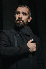 Portrait of young bearded man - business professional - looking aside with his hand at his heart...