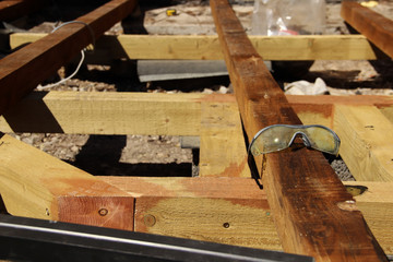 Plastic safety glasses. Used safety goggles lying on a beam.