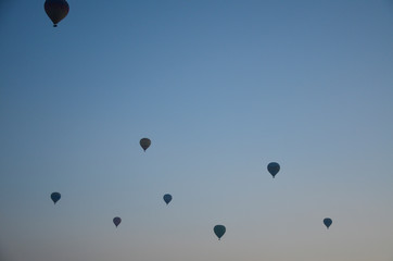 Hot air balloons at sunrise flying in the sky along valleys at Cappadocia of Goreme, Turkey