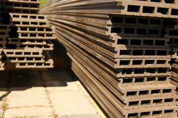 Profile view of composite decking planks put in a pile. WPC decking.